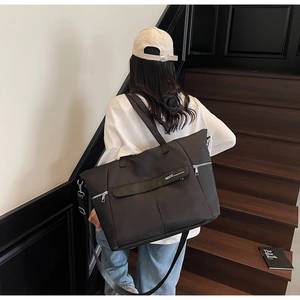 Détail du grand sac cabas noir avec logo NOCO et bandoulière réglable pour un usage quotidien