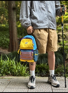 Detail of multi-color outdoor backpack with bungee cord and mesh side pockets in nature