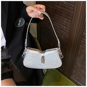 Detail shot of silver handbag with leopard texture and metallic twist lock mechanism