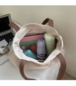 Top view of spacious canvas tote bag interior with tablet, water bottle and books