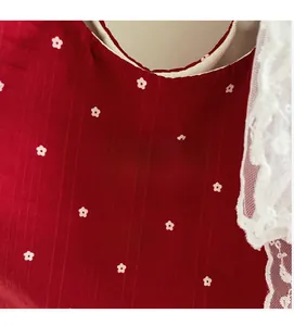Gros plan sur le sac en toile rouge à fleurs avec étiquette et bordure en dentelle