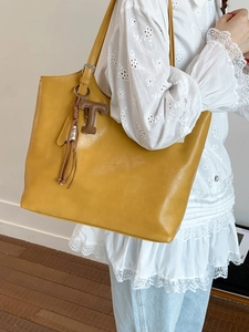 Bolso tote vintage de cuero sintético amarillo jengibre con colgante T y borla