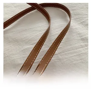 Détail de la bandoulière en cuir marron avec surpiqûres blanches contrastées