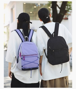 Outdoor view of lightweight purple and black travel backpacks with bungee cords