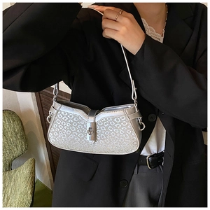Detailed close-up of a silver leopard print crescent bag with metallic buckle lock