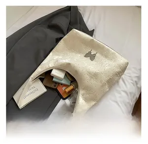 Vue détaillée de l'intérieur spacieux du sac cabas crème avec gaufrage papillon
