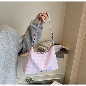 Détail du sac à carreaux lilas avec logo métallique et bandoulière ajustable