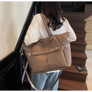 Détail d'un grand sac cabas marron foncé en nylon imperméable avec plusieurs poches