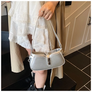 Detailed view of silver baguette shoulder bag with metallic finish and rotary buckle