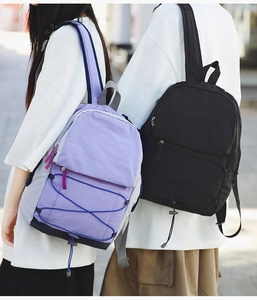 Detail of purple and black lightweight outdoor backpacks with elastic bungee cord design