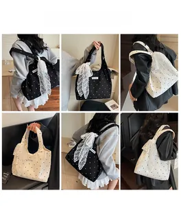 Sac fourre-tout en toile à pois avec pendentif noeud en dentelle porté par un mannequin
