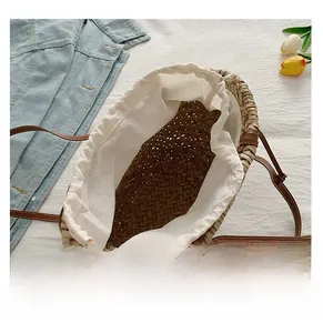 Détail du sac cabas en paille tressée avec doublure à cordon et fines lanières en cuir