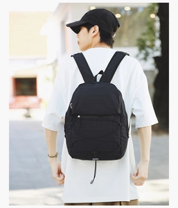 Close-up of a black lightweight nylon backpack with elastic bungee cords and zipper details