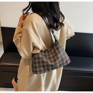 Détail du sac hobo à carreaux avec bandoulière réglable porté par un mannequin