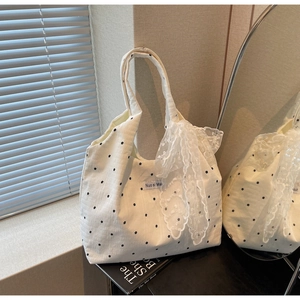 Gros plan détaillé d'un sac cabas en toile fleurie avec un ruban en dentelle blanche