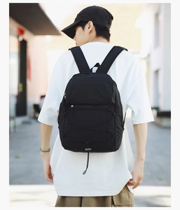 Detail of a lightweight black sports backpack with drawstring on a female model's back