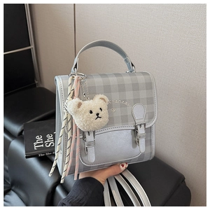 Détail du mini sac à dos à carreaux argentés avec breloque ours et broderie chanzab