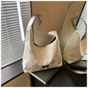 Détail de l'imprimé papillon argenté et boucle métallique sur le sac hobo blanc