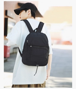 Side view of black lightweight backpack with elastic cords on outdoor model