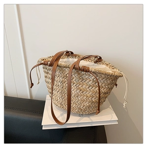 Détail du sac cabas en paille avec lanières en cuir marron et doublure en toile à cordon