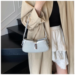 Detail of silver glitter baguette bag featuring leather strap and metallic buckle closure