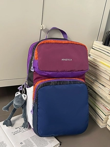 Large color-block backpack with purple and orange panels and a plush frog pendant