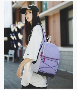 Detail view of purple and grey outdoor backpack with adjustable blue elastic bungee system