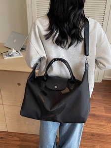 Black large capacity travel tote bag with leather handles and wide shoulder strap