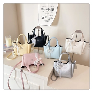 Mini tote bags display in various colors with elegant lace pearl bow charms on textured leather