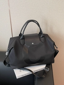 Large black nylon travel tote bag with 'C' logo and adjustable shoulder strap