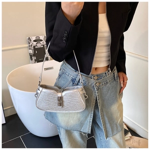 Detail showing silver sequin shoulder bag with wave edge design and metal buckle
