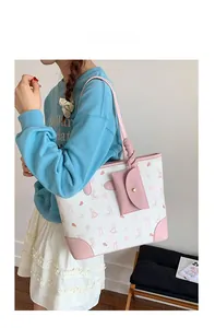 Detail of cream printed tote bag with pink rabbit patterns and matching small coin purse