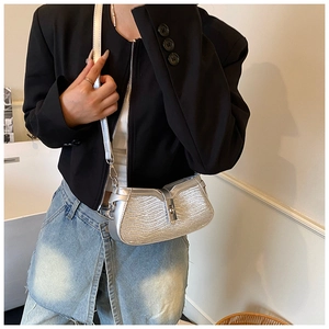 Detailed shot of silver glitter textured underarm bag with a metallic twist lock buckle