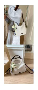 Detail of cream canvas tote bag with leather strap and cute plush chicken pendant