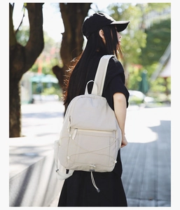 Close-up of lightweight off-white backpack with elastic drawstring and durable nylon fabric