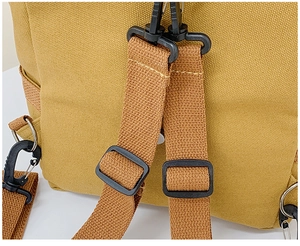 Detailsicht der verstellbaren Riemen und Metallhaken am gelben Canvas-Rucksack