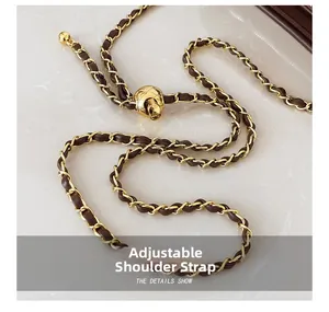 Détail d'une bandoulière en chaîne dorée ajustable avec cuir tressé et boule en métal