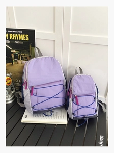 Detail of purple hiking backpack with blue elastic bungee cord and side mesh pockets