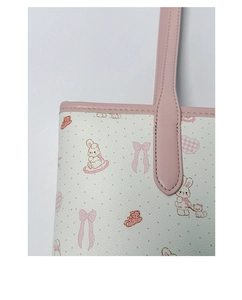 Close-up of the pink leather trim and cute cartoon animal print on a white tote bag
