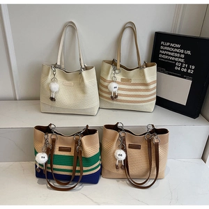 Détail de quatre sacs fourre-tout en maille colorée avec anses en cuir et charme en peluche