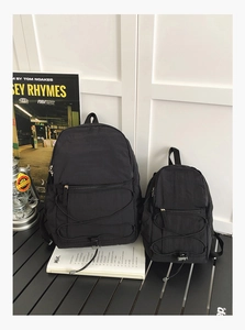 Detail of black nylon backpack set with elastic cords on a camping folding table