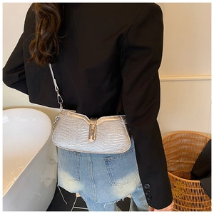 Silver metallic baguette bag with wave texture and chain strap worn by a model