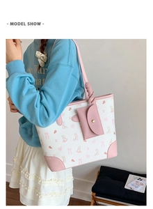 Detail of sweet canvas tote bag with pink rabbit prints and matching leather pouch charm