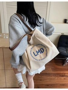 Minimalist canvas tote bag with LMD embroidery and brown straps for daily commute