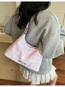 Sac à bandoulière à carreaux rose et blanc porté avec une tenue décontractée