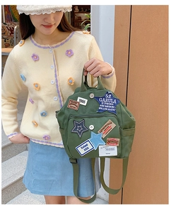 Detailansicht eines armeegetreuen Canvas-Rucksacks mit Vintage-Patches am Model