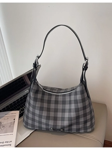 Sac baguette à carreaux gris sur siège en cuir avec ordinateur pour un look bureau