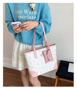 Close-up of pink bunny print and mini coin purse detail on the white tote bag