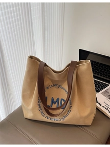 Minimalist canvas tote bag with LMD embroidery shown in a modern office desk setting