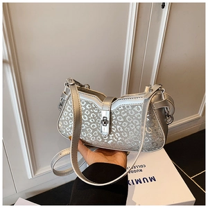 Detail of silver sequin leopard print handbag with metallic rotary lock and slim strap